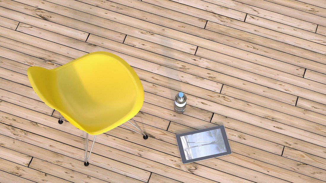 Yellow chair, water bottle and digital tablet on wooden terrace