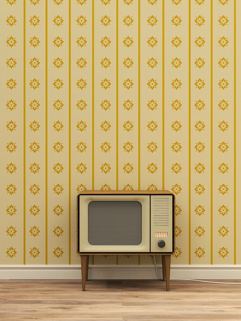 Retro Fernseher vor gelb gemusterter Tapete