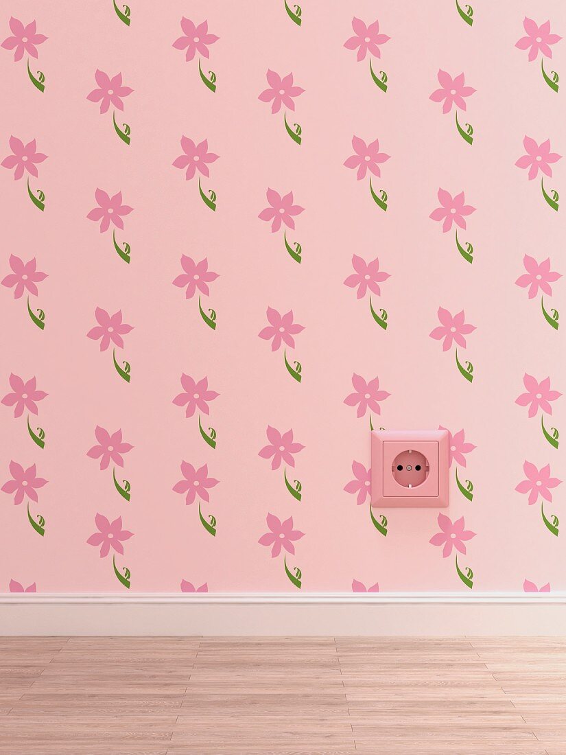 Pink electrical outlet on pink wallpaper with floral design
