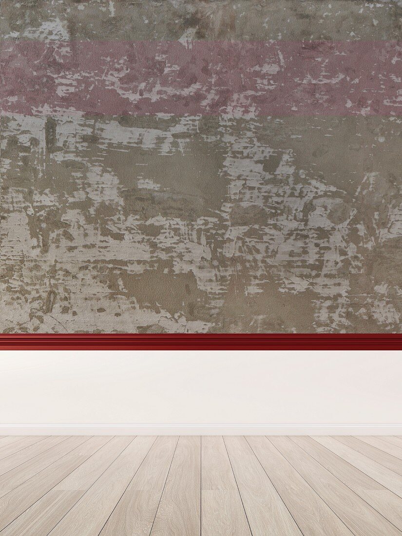 Rough concrete wall above wooden floor, white-clad wall base and red chair rail