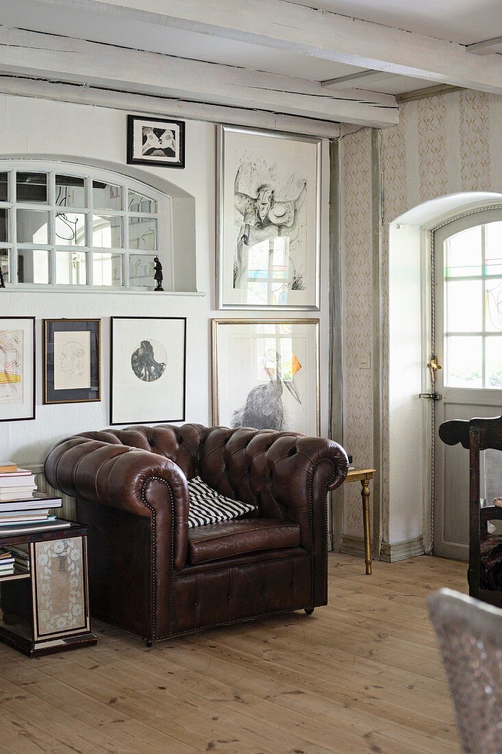 Brauner Ledersessel vor Wand mit Bildersammlung in rustikal ländlichem Zimmer
