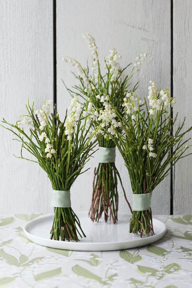 Posies of lily of the valley on white plate