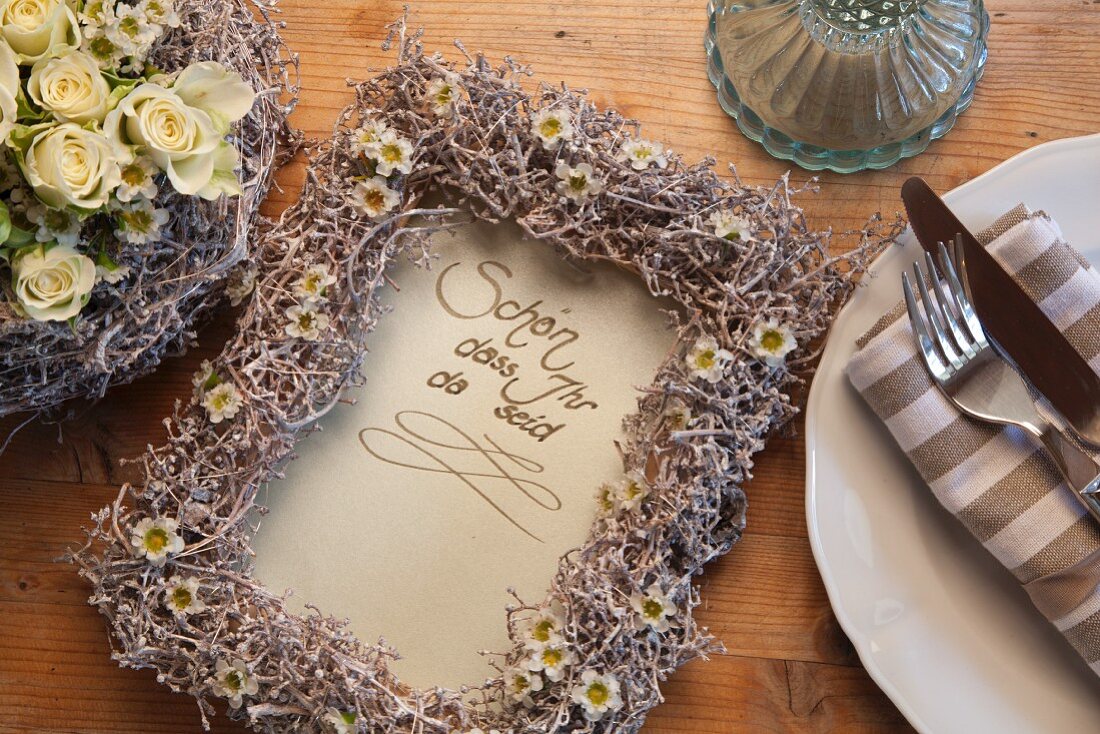 Hand-written message with frame decorated with waxflowers and grape stems painted white