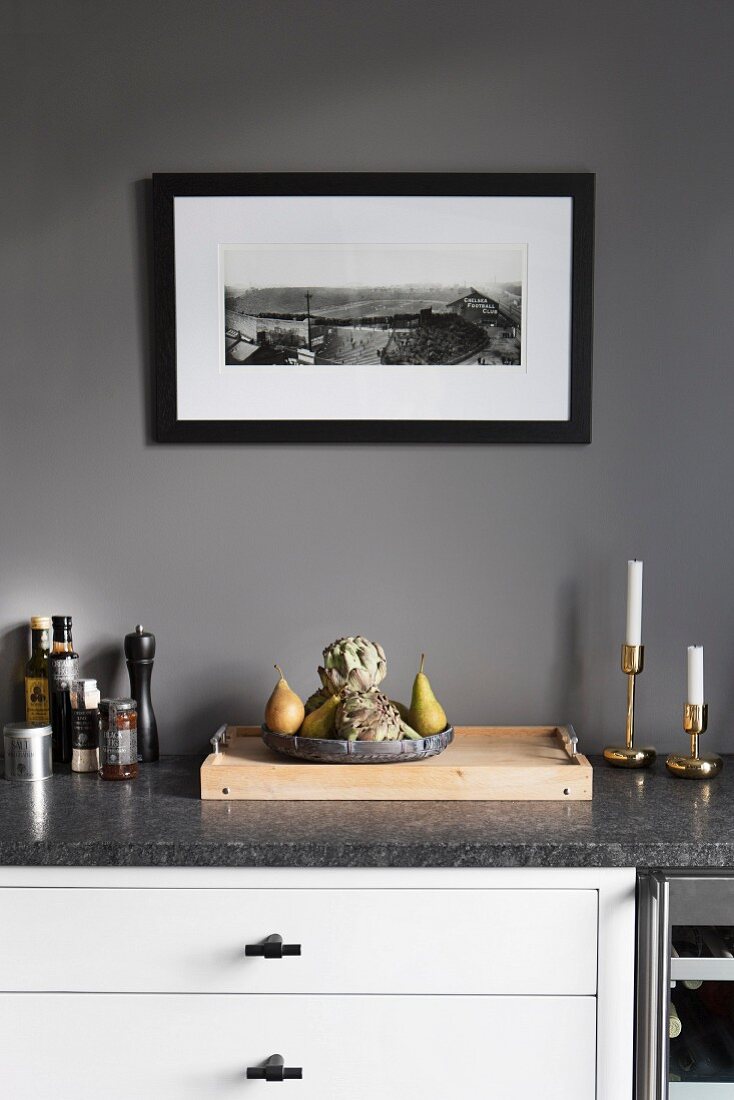 weiße Küchenzeile mit Steinplatte vor grau getönter Wand