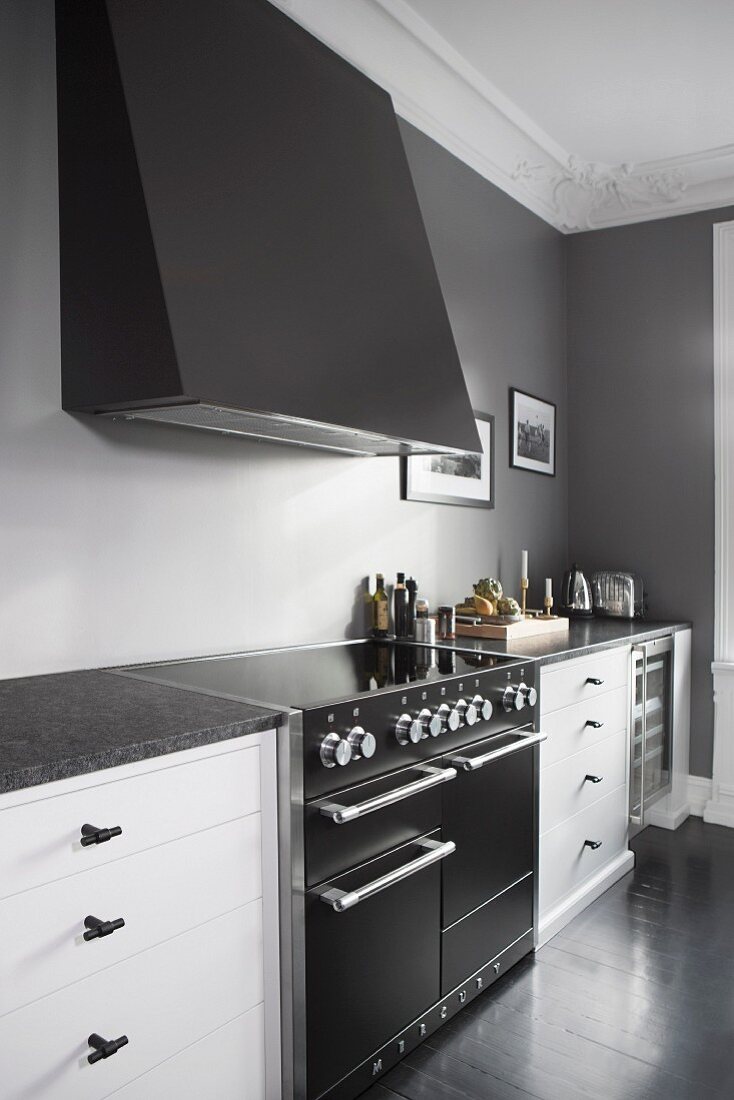 Elegante Küchenzeile mit Dunstabzug an grauer Wand