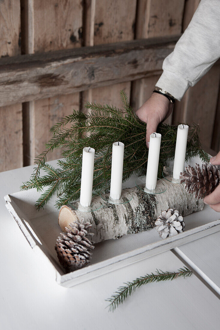 DIY-Kerzenständer aus halbrundem Birkenholz mit vier weißen Kerzen und Tropfenfängern aus Glas