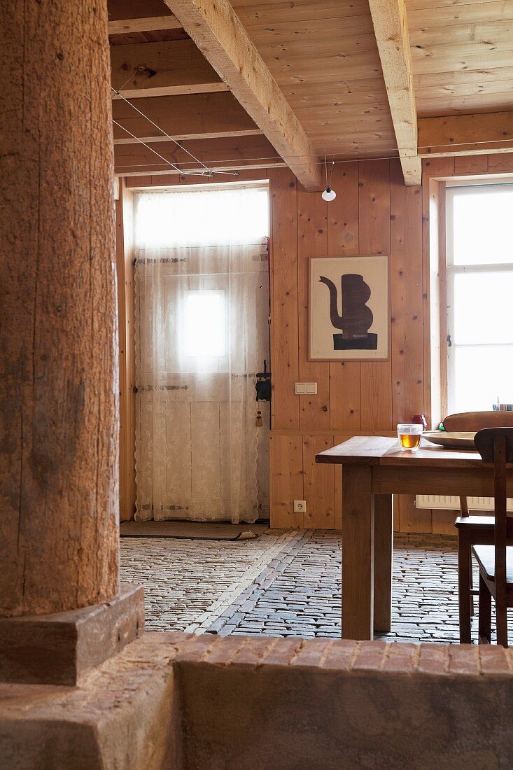 Essbereich in renoviertem Haus mit rustikalem Pflasterboden und Holzverkleidung