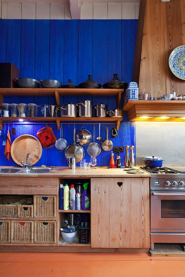 Küchenzeile mit Massivholzunterschränken, oberhalb blau lackierter Holzwand