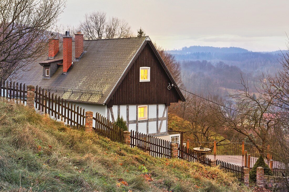 Renoviertes Landhaus am Hang mit Dämmerstimmung und Landschaftsblick