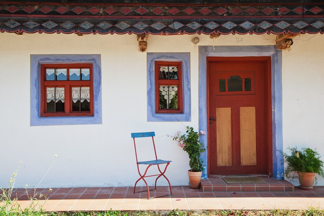 Ausschnitt eines alten, renovierten Bauernhauses mit blauen Faschen um Fenster und Tür