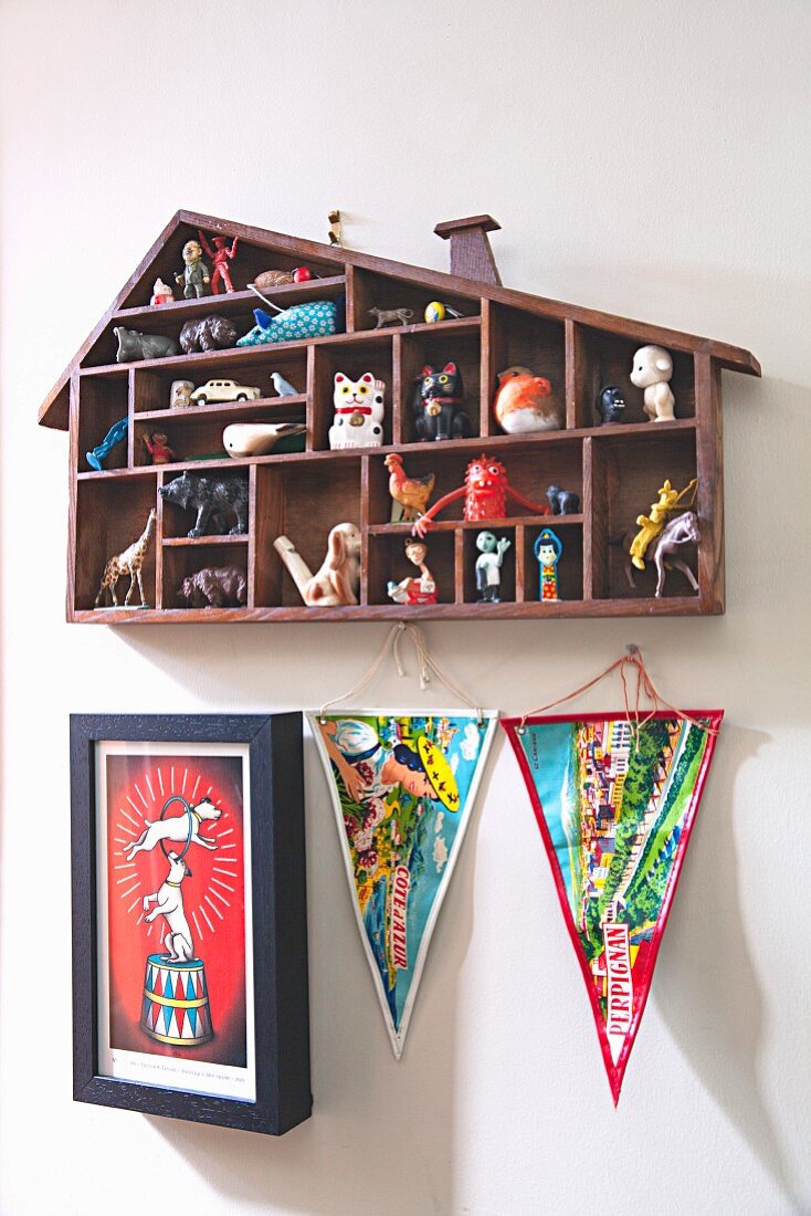 House-shaped display case above pennants and picture on wall