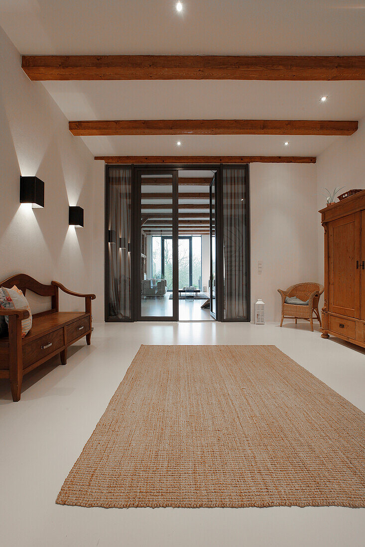 Heller Wohnraum mit Sisalteppich und traditionellen Holzmöbeln