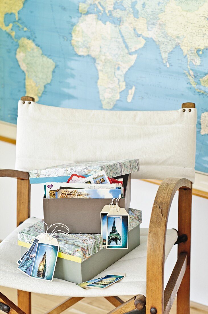 Kartons mit neugestaltetem Deckel aus alten Landkarten und selbstgemachte Kartenanhänger mit Reisefotos