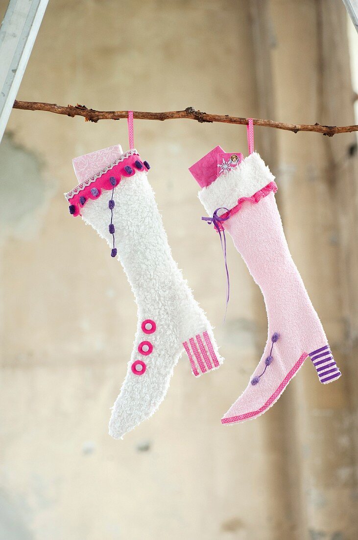 Hand-crafted Christmas stockings filled with gifts and hung from branch