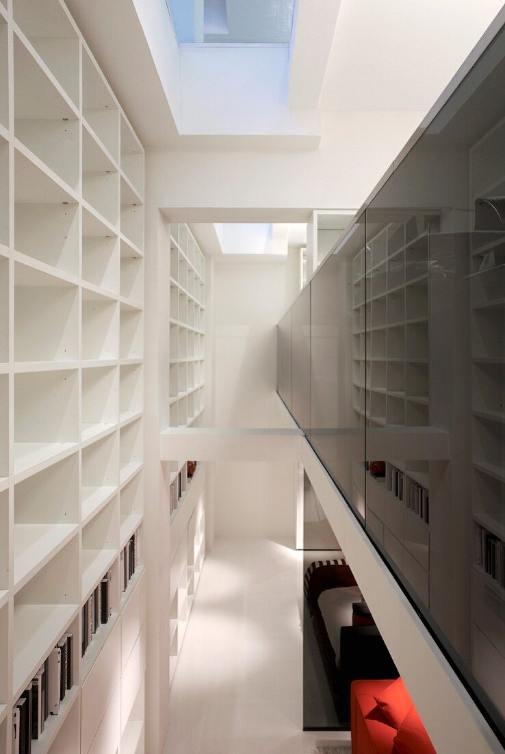 Open-plan, contemporary, double-height showroom house; white shelving with many compartments to one side