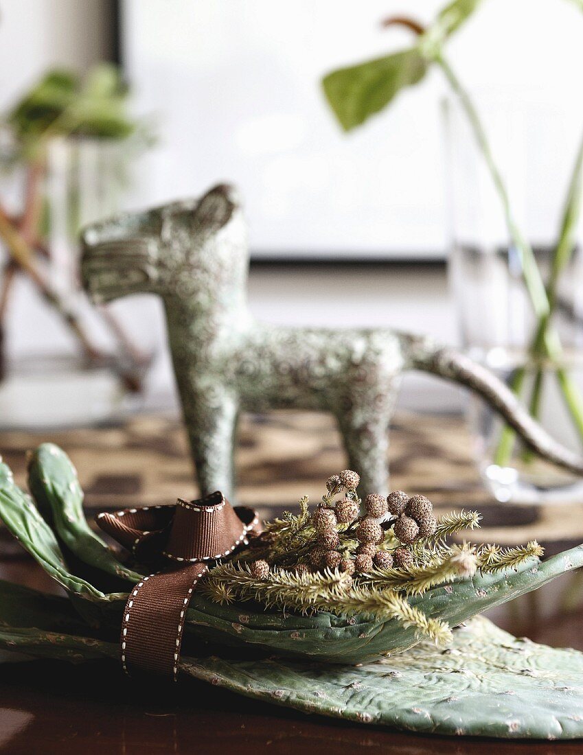 Bowl of twigs and dog ornament on table