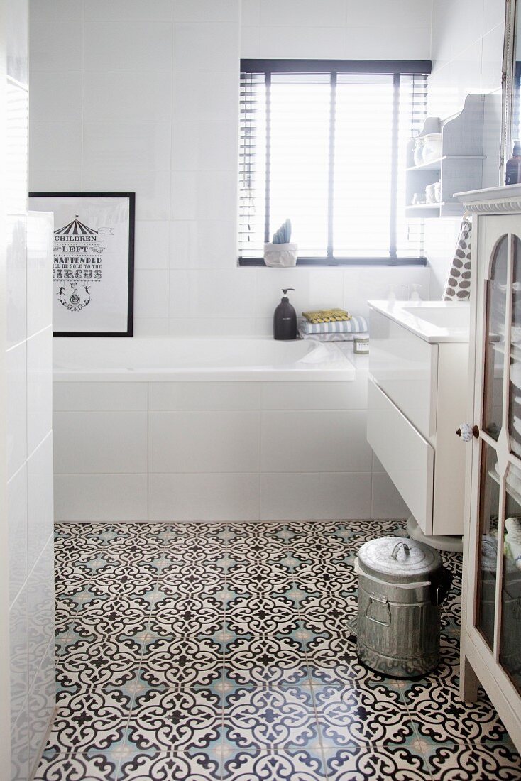 White bathroom with Moroccan-style ornamental tiles on floor
