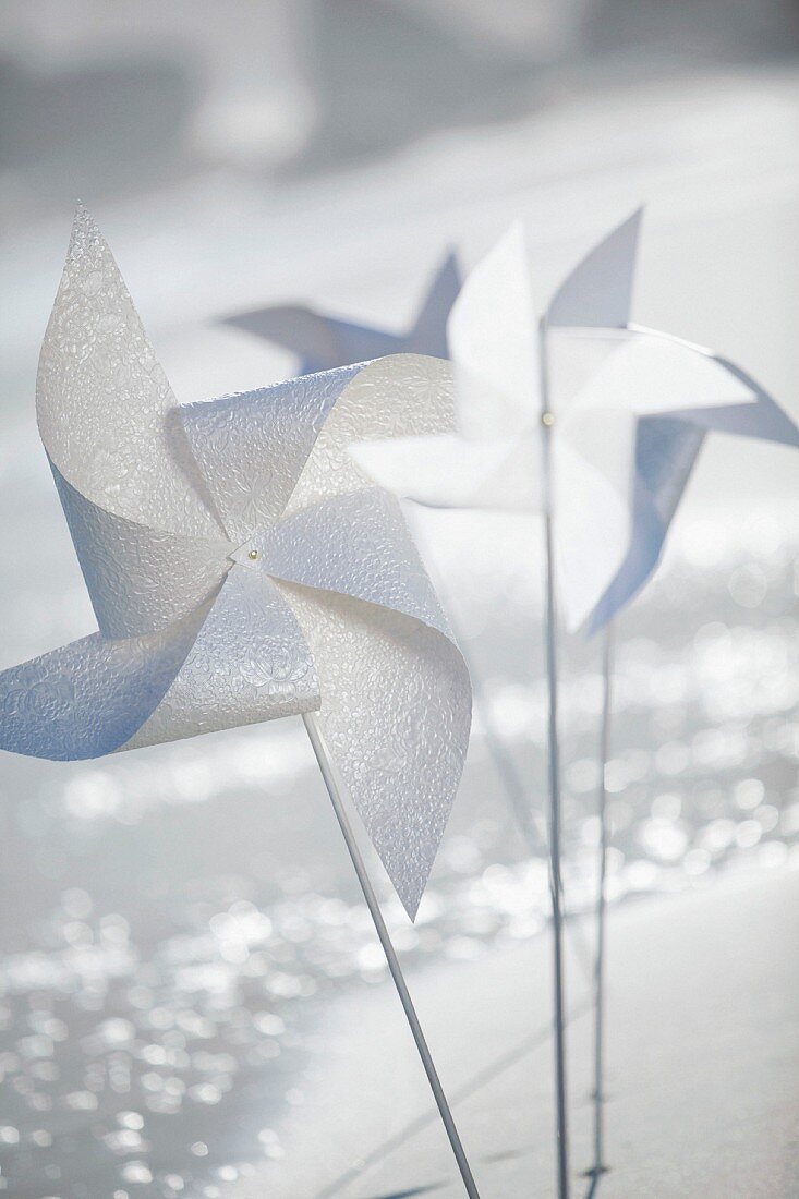 White, plastic windmills in glittering light