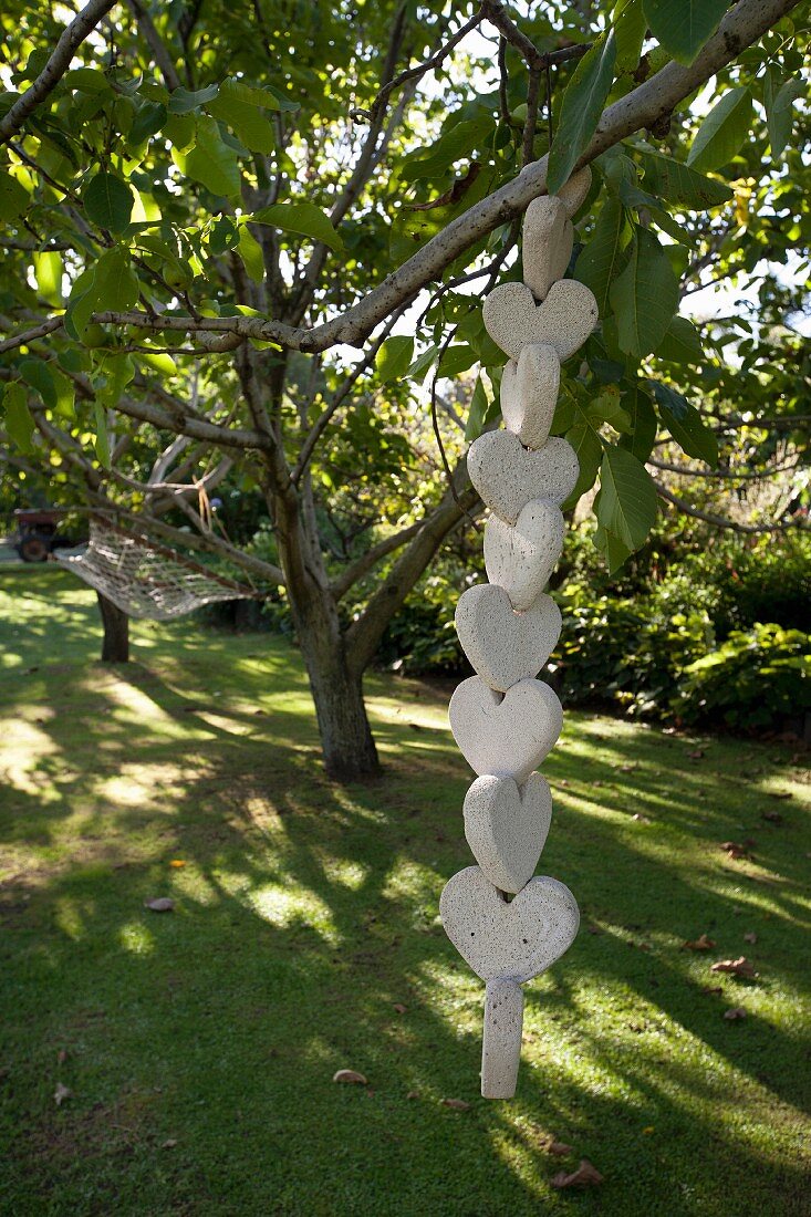 Tree branch support made from stacked love-hearts on lawn