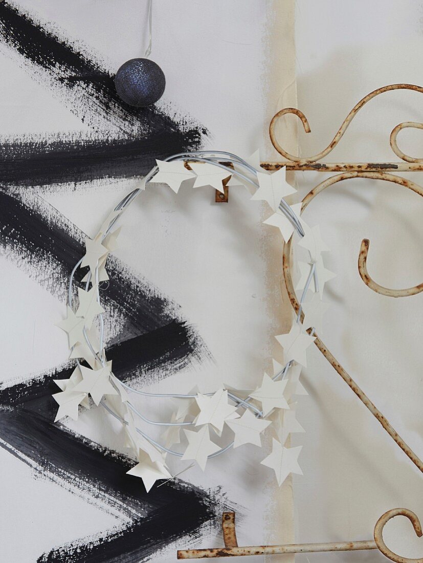 Wreath of paper stars hung from vintage-style metal trellis
