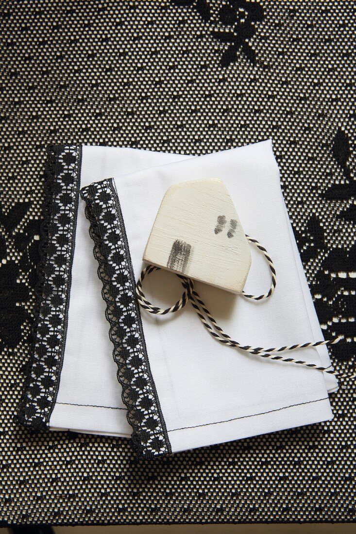 White linen napkin with black trim and wooden tag