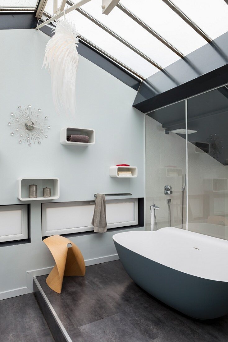 Bathroom with glass roof and designer bathtub on platform