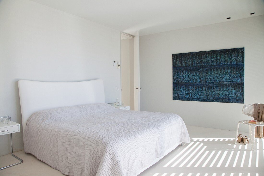 Minimalistisches weißes Schlafzimmer mit Wanddekoration in Blautönen