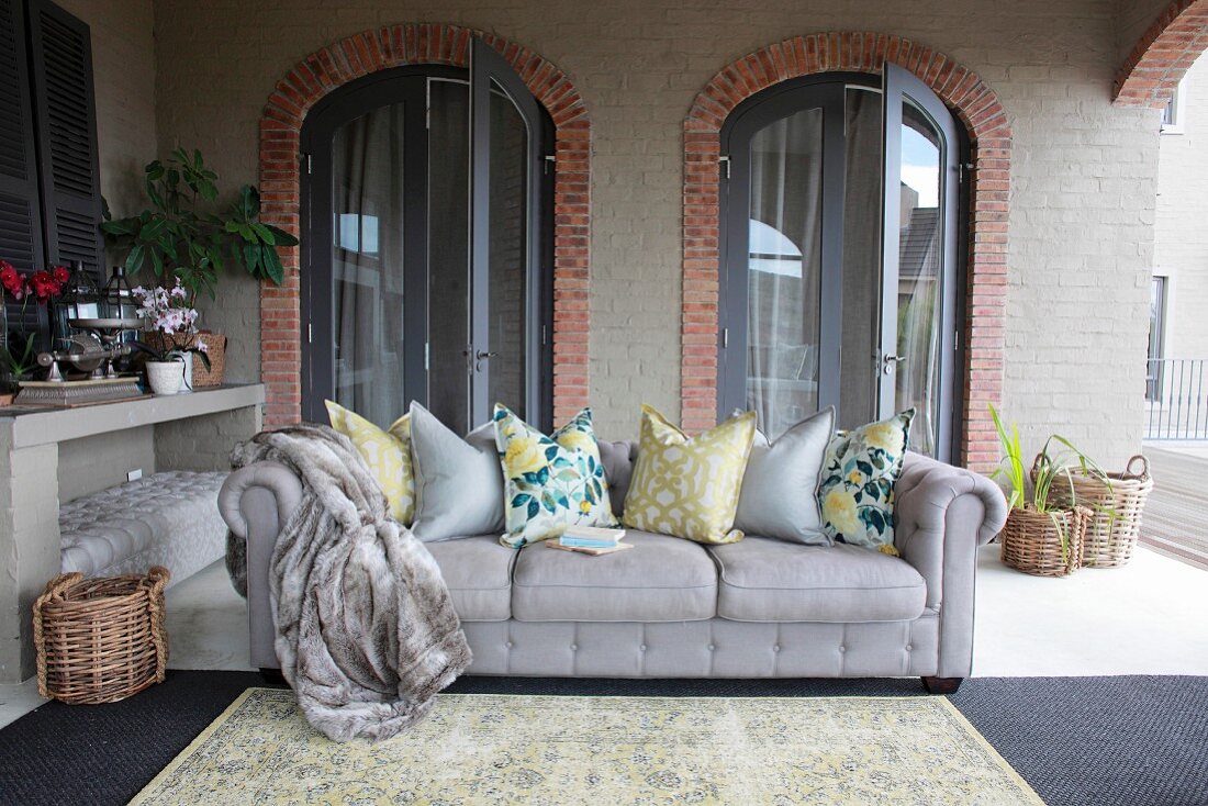 Grey sofa with scatter cushions in loggia