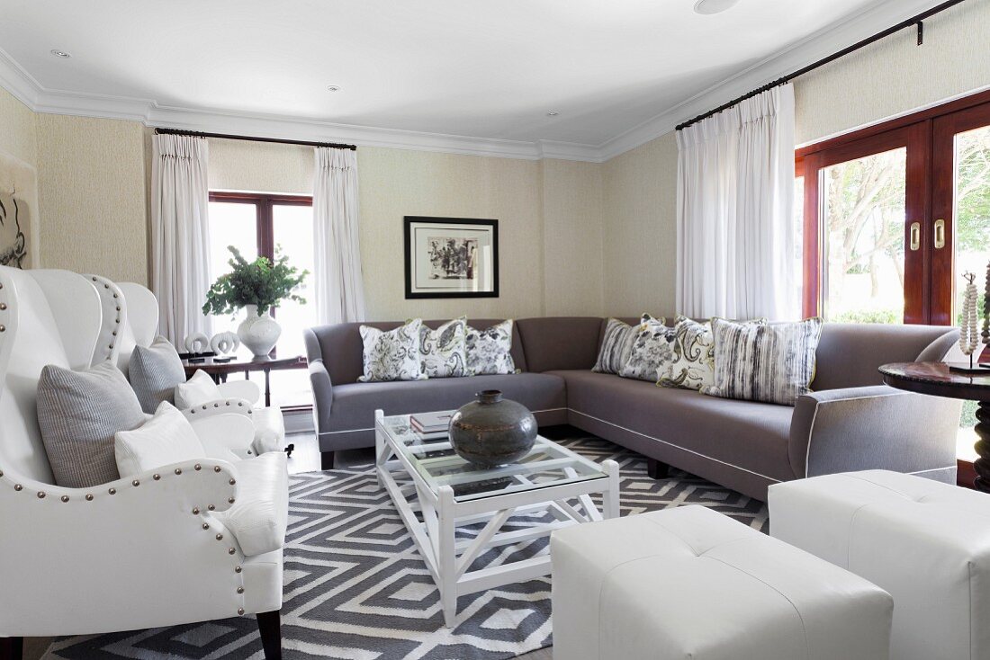 Große, elegante Sofalandschaft in klassischem Wohnzimmer mit hellen und grauen Polstermöbeln