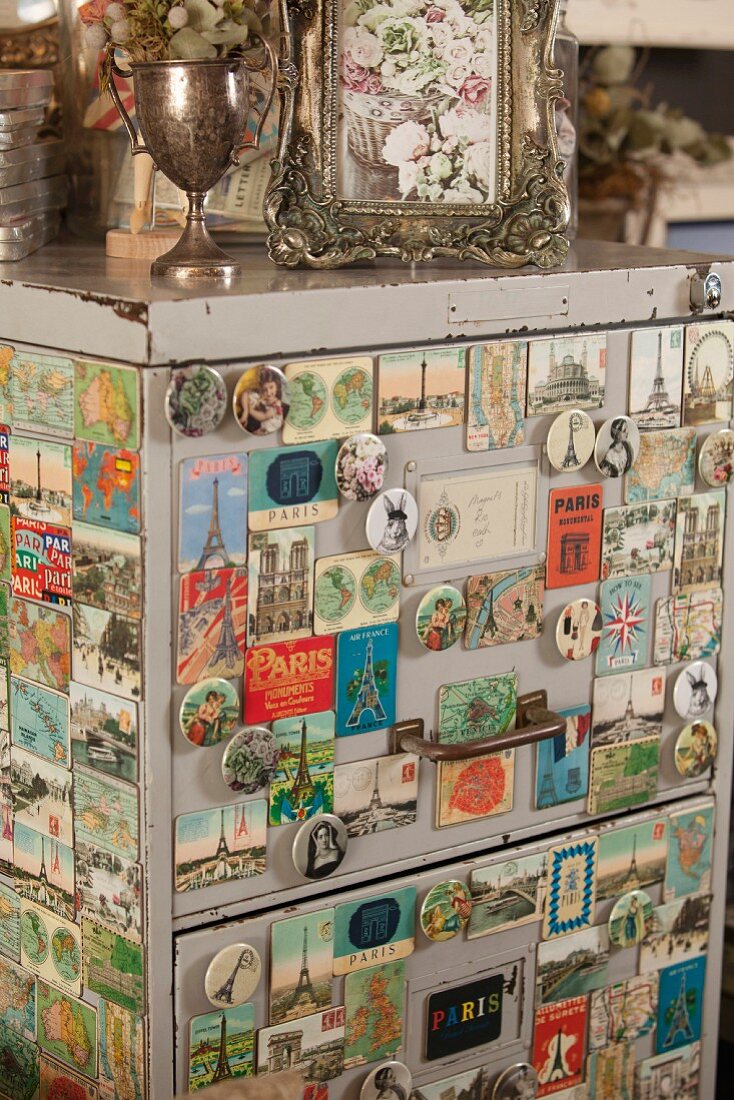 Vintage filing cabinet covered in old magnets with Paris motifs