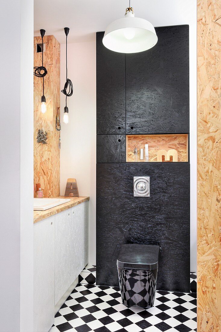 Maßgefertigtes Badezimmer aus OSB-Platten, Schachbrettboden und schwarzer Toilette