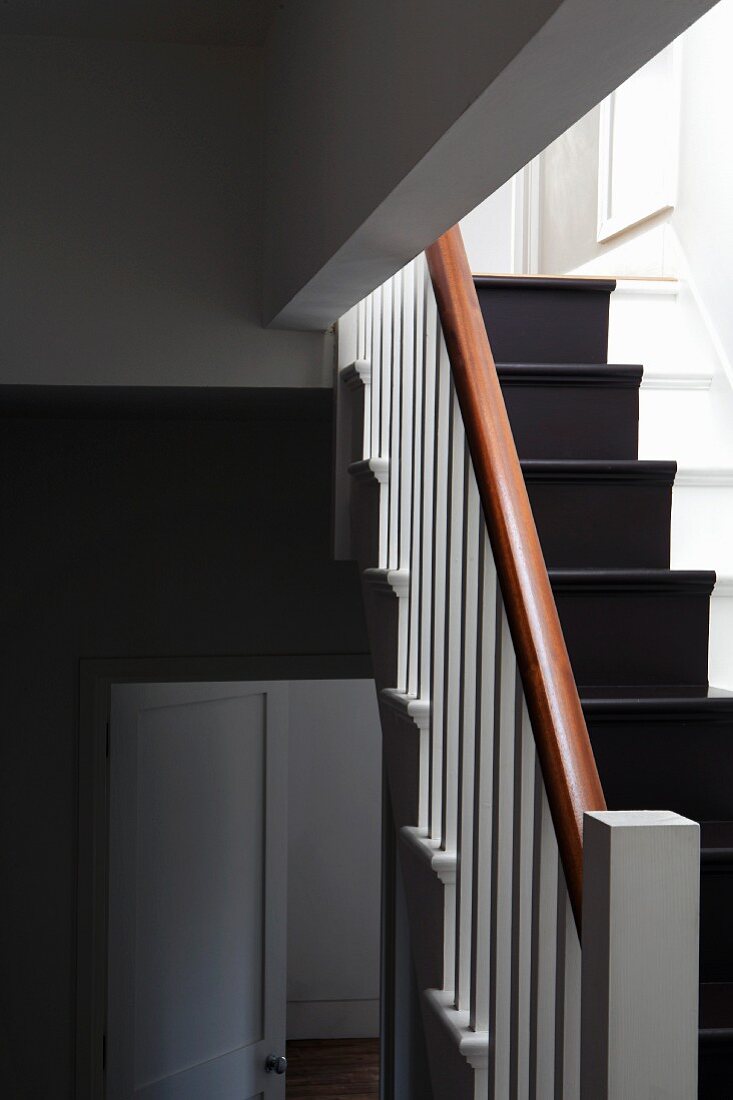 Stairwell with black, runner-style striped painted on white wooden steps