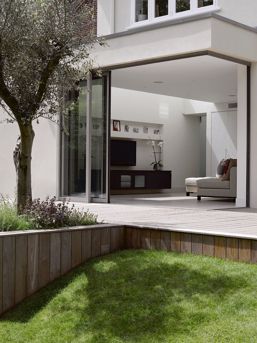View from garden across terrace into modern living room