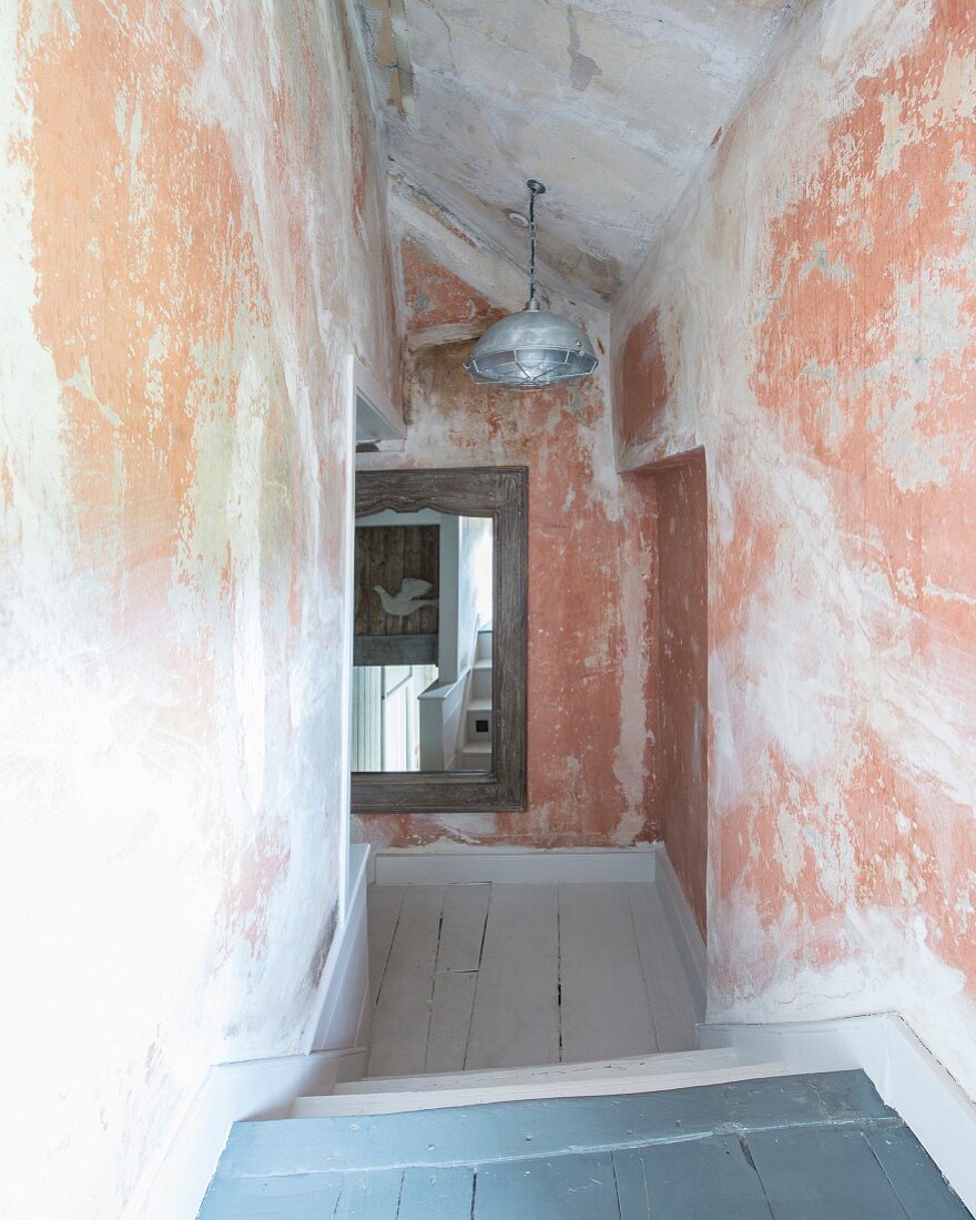 Corridor with different levels, niches and patinated walls in attic of old country house