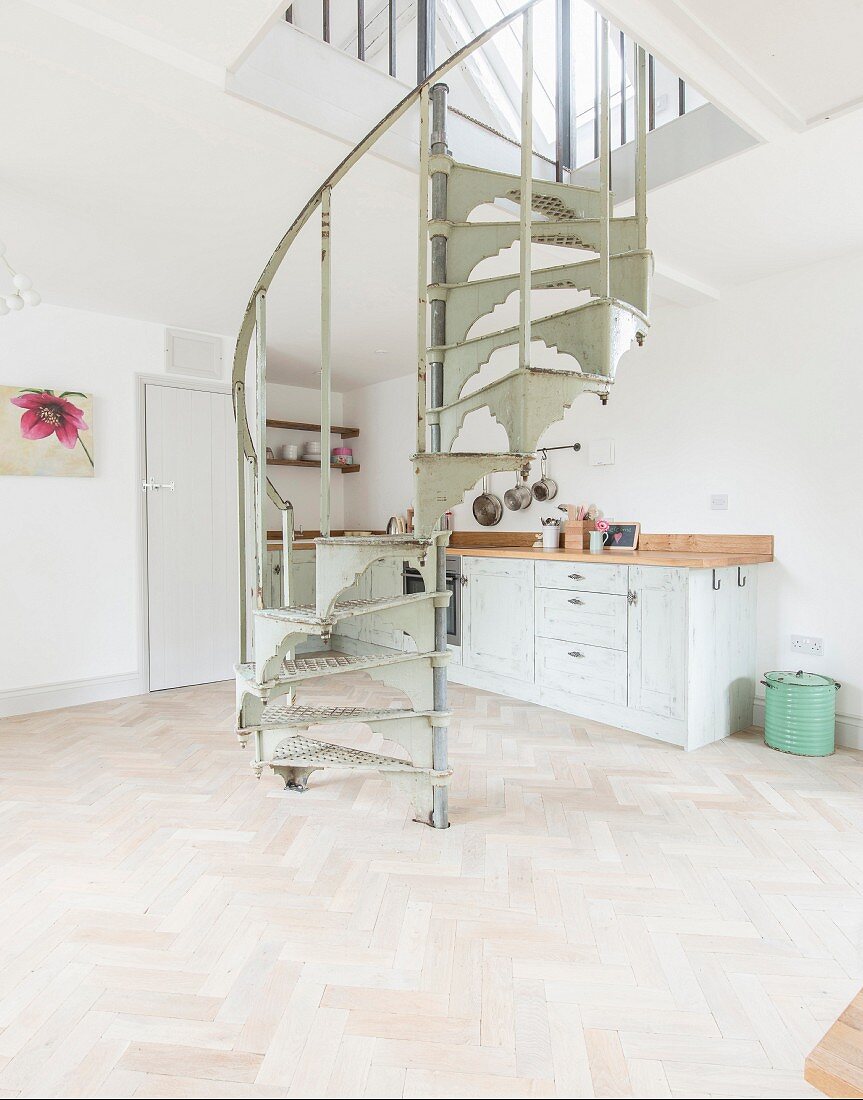 Vintage spiral staircase in kitchen-dining room with herringbone parquet