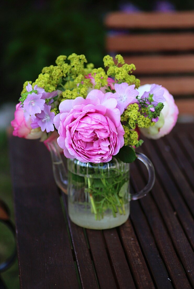 Posy of roses (variety ' Princess Alexandra'), mallow and lady's mantle in small, glass teapot