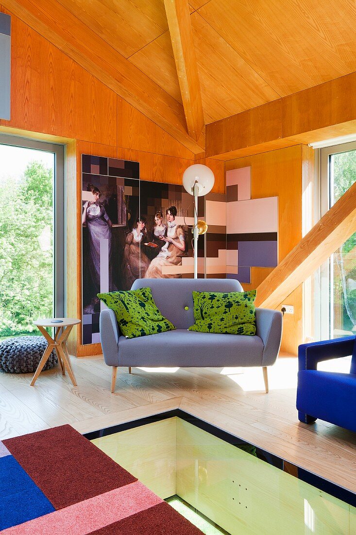 Designer-Sofa in Zimmerecke mit Holzverkleidung und verglastem Bodenbereich