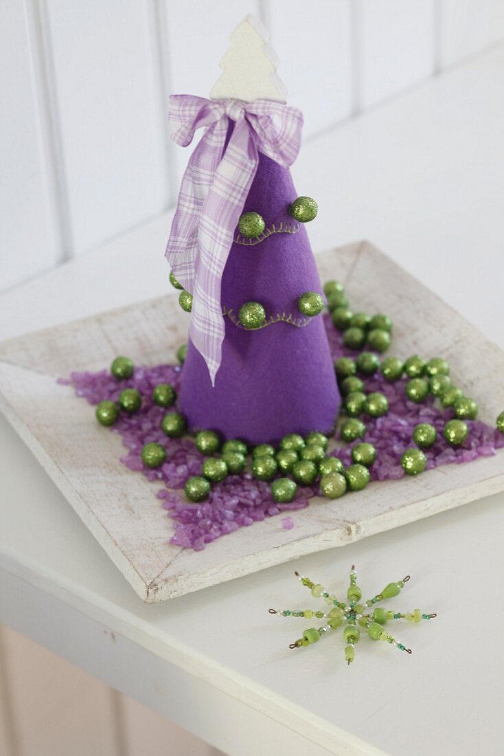 Purple felt Christmas tree on plate with purple gravel and green baubles
