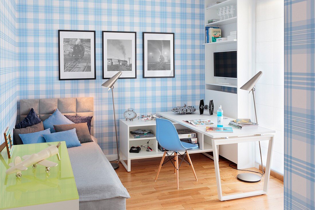 Bett und Schreibtisch mit Klassikerstuhl in Jugendzimmer mit blau-weiss karierter Tapete an Wand