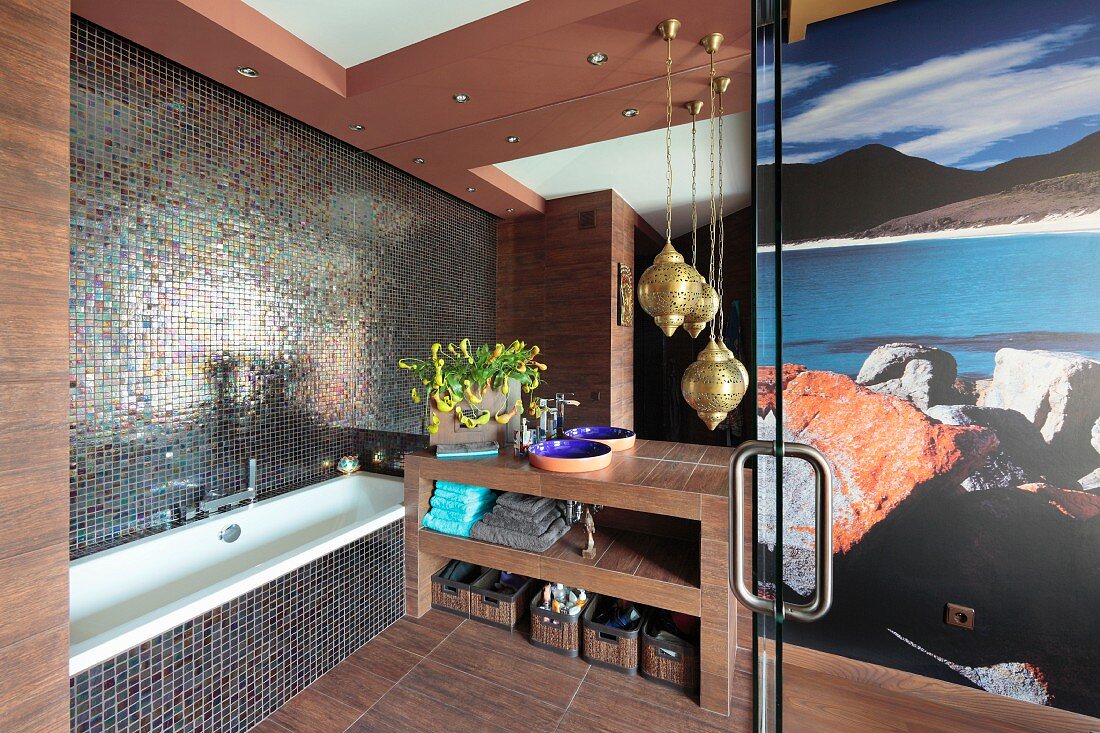 Badewanne neben Waschtisch und Messing Hängeleuchten im Designerbad mit Mosaikfliesen