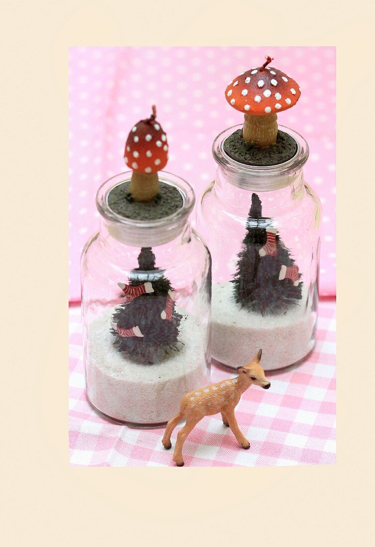 Glasgefässe gefüllt mit Sand & Tannchenbäumchen als weihnachtliche Kerzenhalter