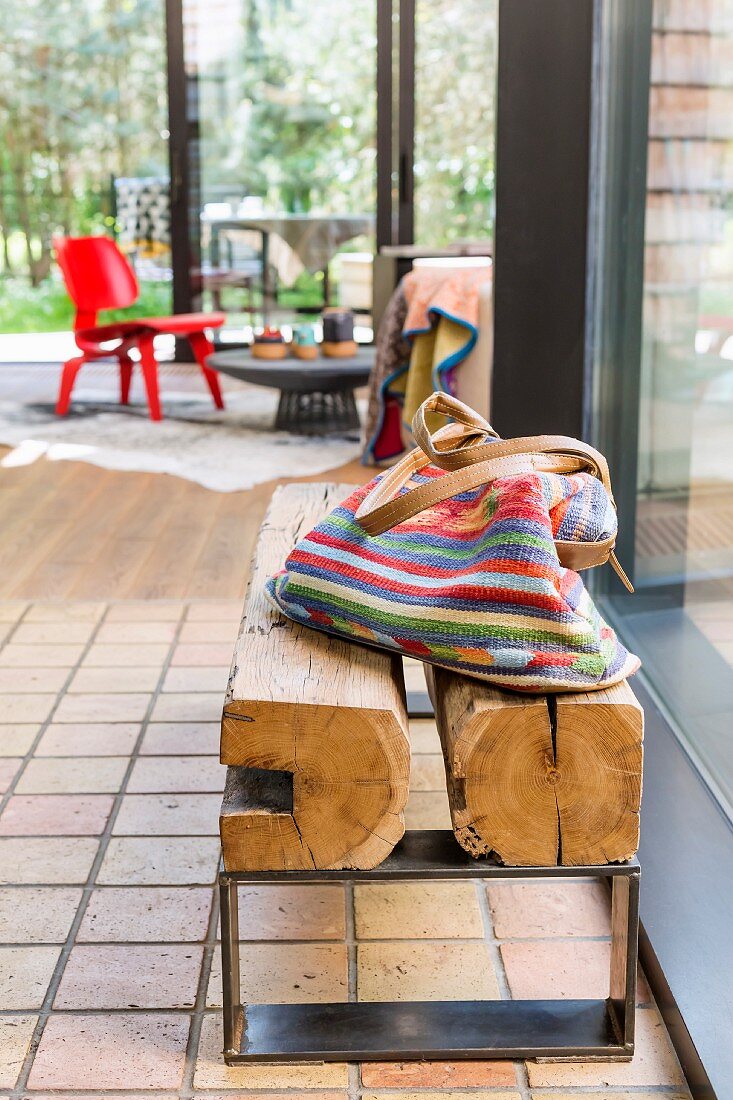 Striped fabric bag on rustic wooden bench with metal frame