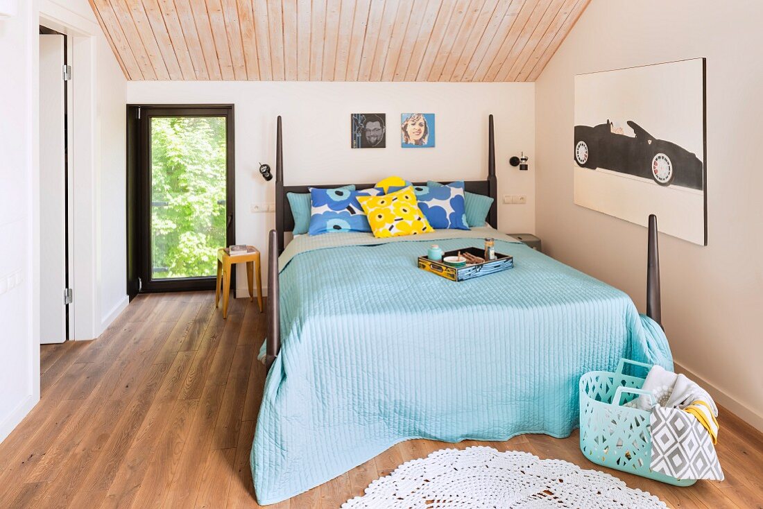 Türkise Tagesdecke auf Doppelbett, mit Säulen an den Ecken, in modernem Schlafzimmer mit holzverkleideter Decke