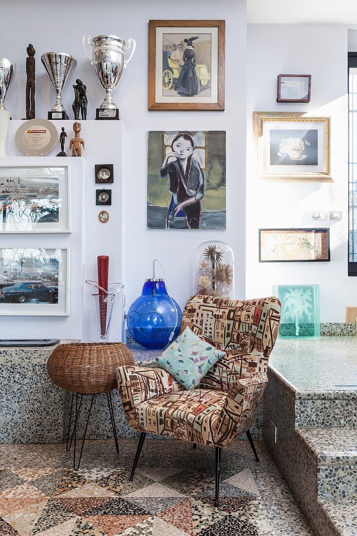 Retro Sessel mit gemustertem Bezug auf Mosaikboden, an Wand Bildersammlung