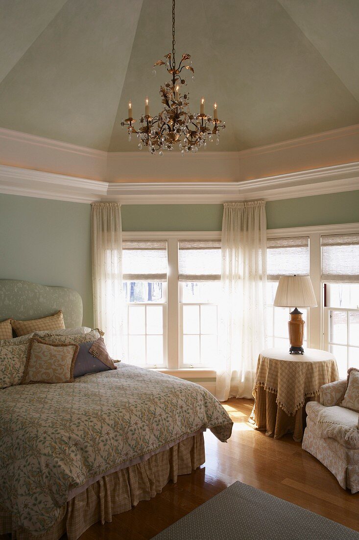 Edles Schlafzimmer mit Kronleuchter und pastellgrüner Wand- und Deckenfarbe