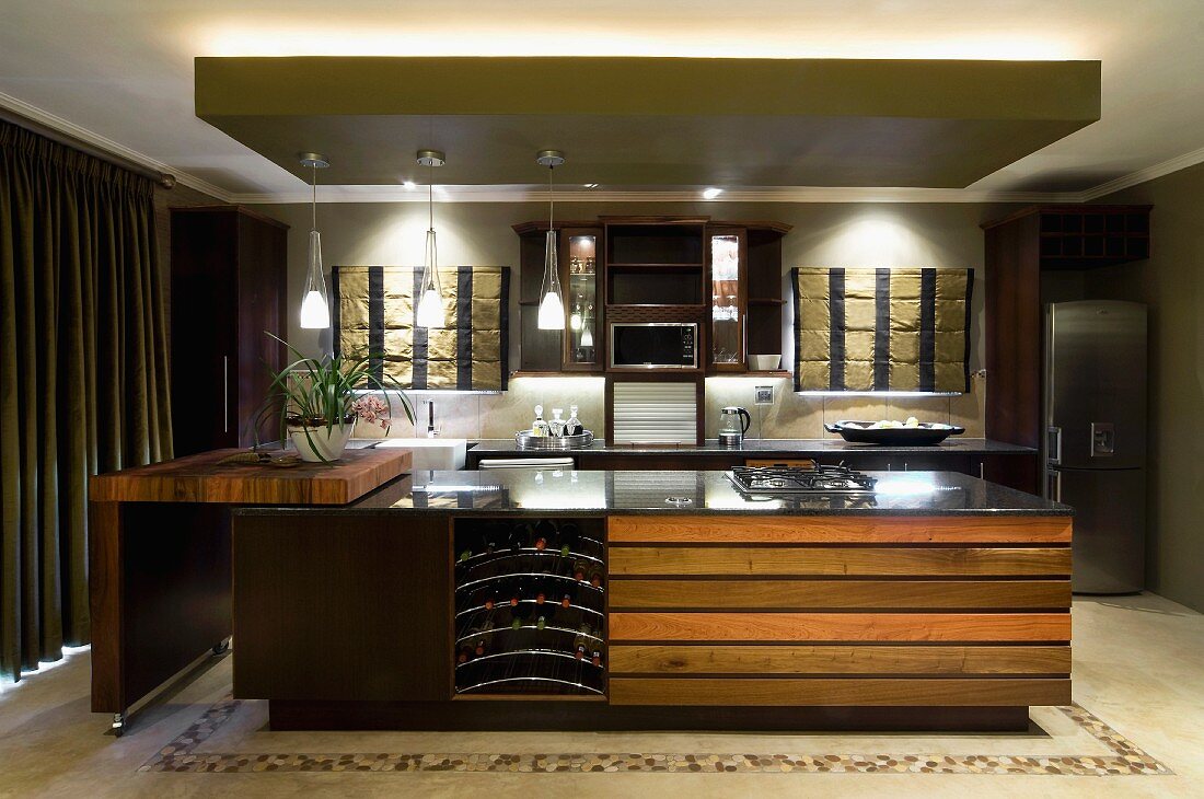 Illuminated island counter with integrated wine rack and swivelling kitchen trolley
