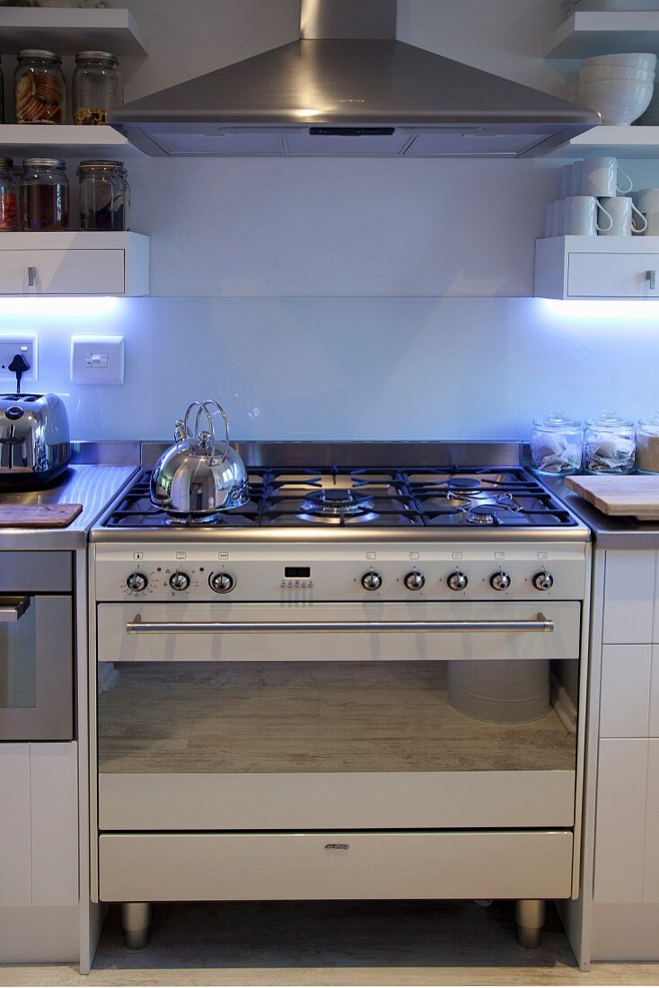 Gas cooker below stainless steel extractor hood integrated into kitchen counter