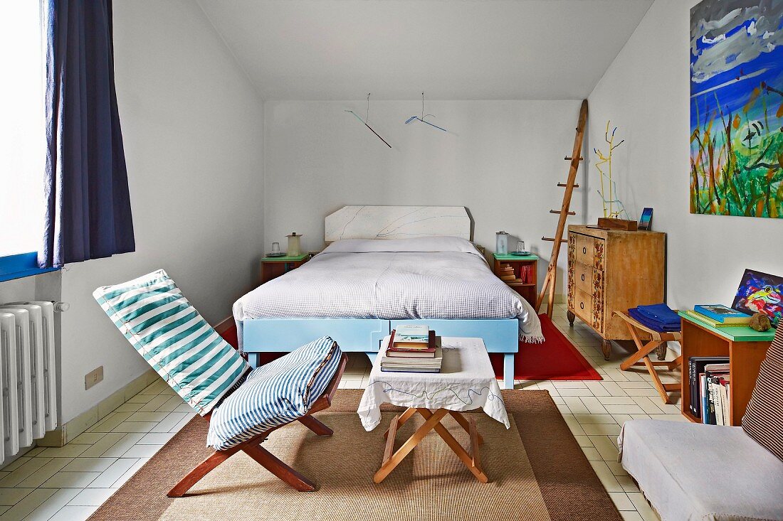 Einfaches Schlafzimmer mit Holzklappmöbeln, Doppelbett und künstlerischem Flair
