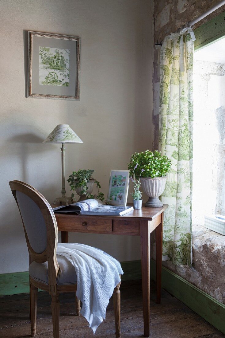 Kleiner Schreibtisch aus Holz und barocker Stuhl am Fenster mit grünen Toile-de-Jouy-Vorhängen