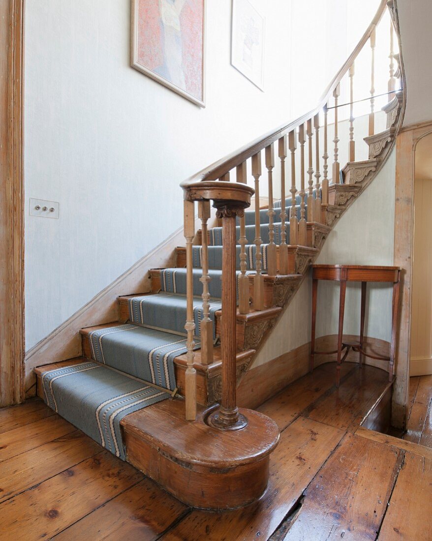Antike Treppe aus Holz mit Teppich und gedrechseltem Geländer, alter Dielenboden